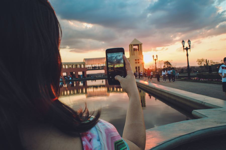 Taking a photo on a smartphone at sunset