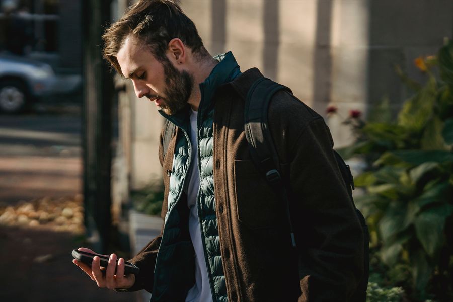 Man checking phone in city street